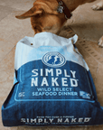 dog sniffing at an open bag of Simply Naked seafood dog food